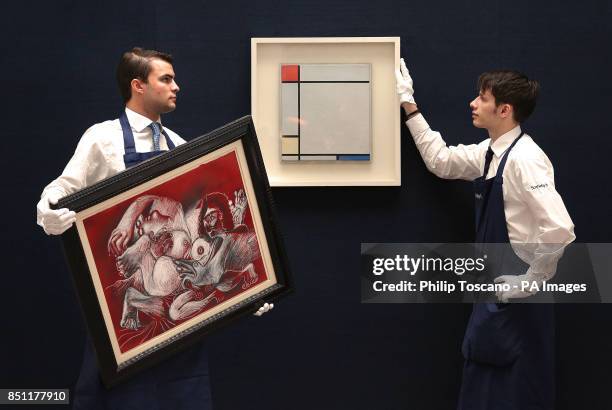 Technicians with 'Etreinte' by Picasso and hanging 'Composition with Red, Yellow and Blue' by Piet Mondrian at Sotheby's in London which are to sold...