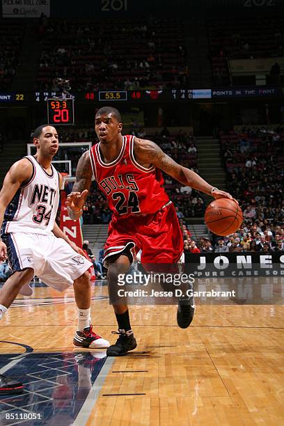 Tyrus Thomas of the Chicago Bulls drives against Devin Harris of the New Jersey Nets during the game at the Izod Center February 25, 2009 in East...