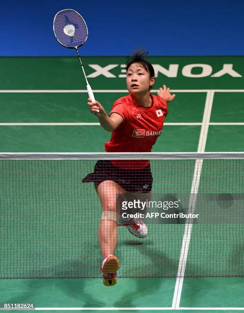 Nozomi Okuhara of Japan hits a return towards Zhang Beiwen of the US during their women's singles quarter-final match at the Japan Open Badminton...