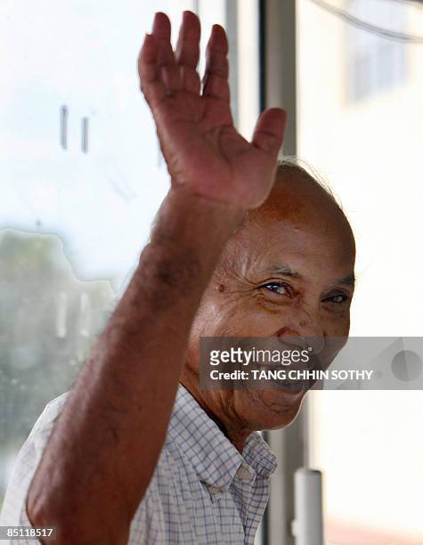 Cambodian survivor from Tuol Sleng prinson, Known as S21, Chum Mey, waves as he walks into the court room during a hearing of former Khmer Rouge...