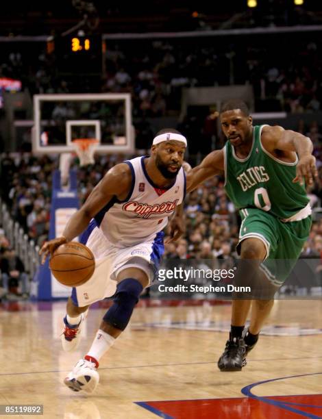Baron Davis of the Los Angeles Clippers drives around Leon Powe of the Boston Celtics on February 25, 2009 at Staples Center in Los Angeles,...