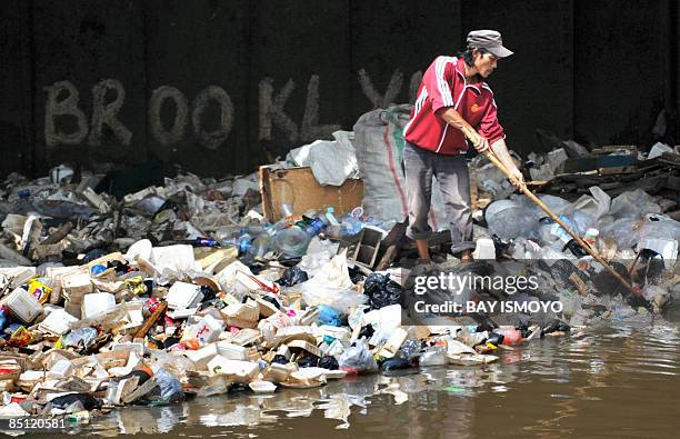 Man collects plastic for resale from the floating rubbish in Jakarta on February 26, 2009. Indonesia's parliament has approved a six-billion-dollar...