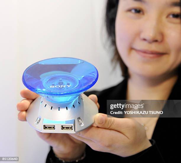 Masayo Endo, an employee for Japanese electronics giant Sony, displays a prototype model of a direct methanol fuel cell battery to charge small...