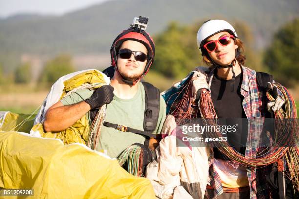 paraglider pilots walking when after landing - farm bailout stock pictures, royalty-free photos & images