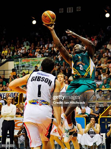 Corey Willliams of the Crocs makes a layup over Adam Gibson of the Dragons during game two of the NBL semi final series between the Townsville...