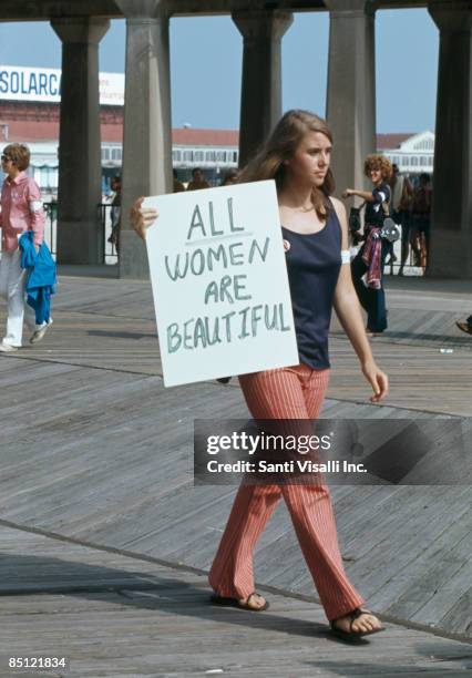 Protest against the Miss America Pageant at Atlantic City, New Jersey, 6th September 1969. A woman walks past with a sign reading 'All women are...