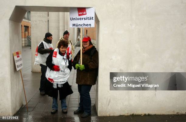 Protestors holding a poster reading "University Munich" search protection from the rain during a protest rally on February 26, 2009 in Nuremberg,...