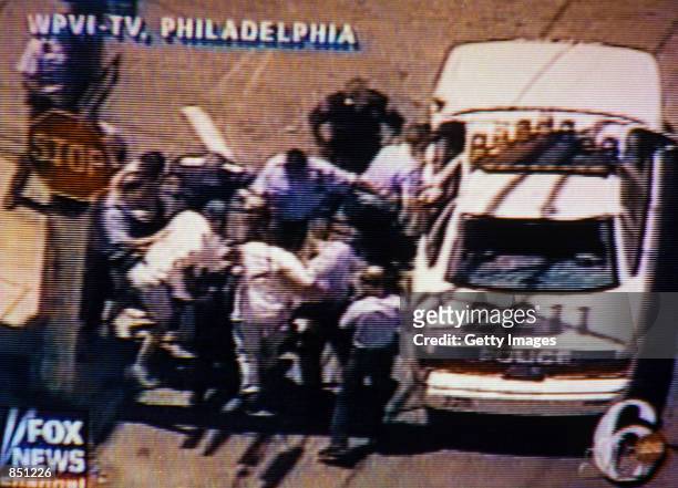 Video still of Philadelphia Police pulling a suspect out of a car and beating him on July 7, 2000 in Philadelphia, PA. The suspect shot at police...