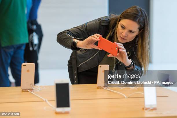 Woman photographs new iPhones at the Apple Store on Regent Street, London, as the iPhone 8 and iPhone 8 Plus go on-sale in the UK.