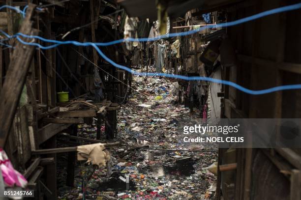 Garbage floats on a creek in Manila on September 22, 2017. - Giant Western consumer products brands led by Nestle, Unilever and Procter & Gamble...