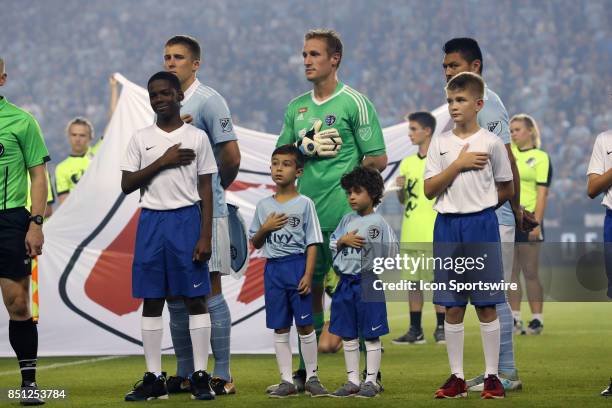 Kansas City's Matt Besler, Tim Melia, and Roger Espinoza with player escorts before the gameas Sporting Kansas City hosted the New York Red Bulls on...