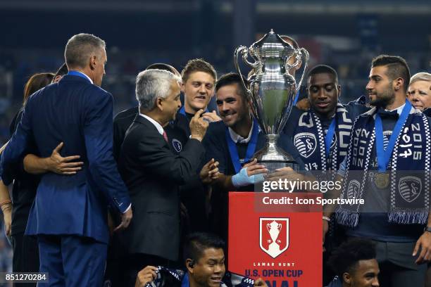 Kansas City's Benny Feilhaber jokingly refuses to left U.S. Soccer Federation president Sunil Gulati have the championship trophyas Sporting Kansas...