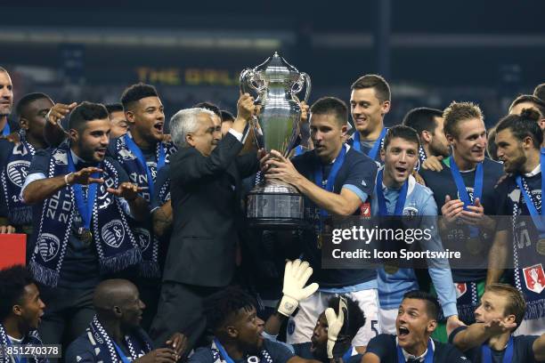 Soccer Federation president Sunil Gulati hands the championship trophy to SKC captain Matt Besleras Sporting Kansas City hosted the New York Red...