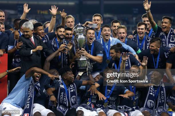 Captain Matt Besler raises the championship trophy overhead while celebrating with his teammates after the gameas Sporting Kansas City hosted the New...
