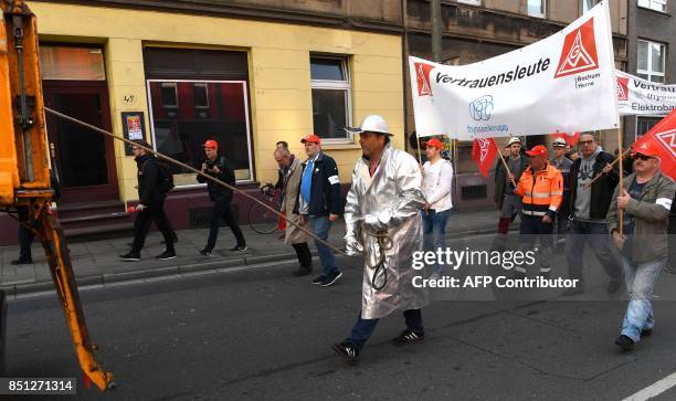 Members of IG Metall trade union hold a banner reading 'people of trust' during a protest of steelworkers of the ThyssenKrupp Steel Europe in Bochum...