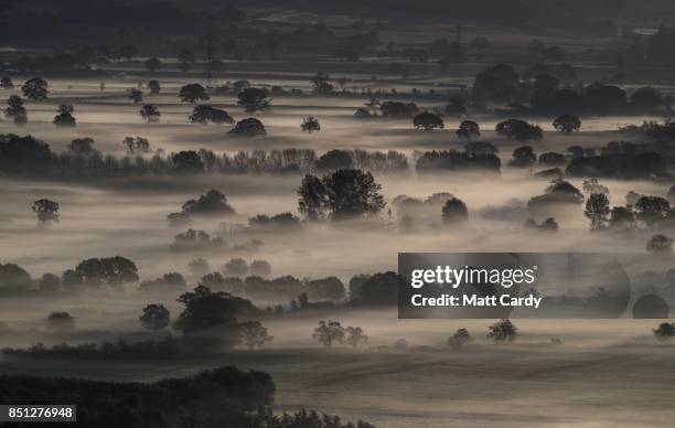 Early morning mist lingers in fields as the autumn sun rises over the Somerset Levels as viewed from Glastonbury Tor near Glastonbury on September...