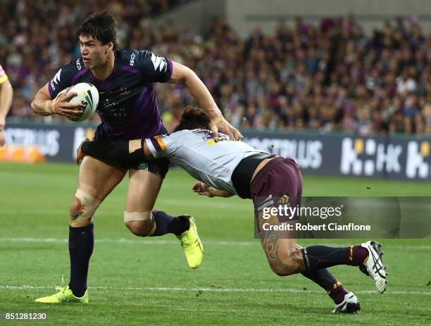 Jordan McLean of the Storm is challenged by Adam Blair of the Brisbane Broncos during the NRL Preliminary Final match between the Melbourne Storm and...