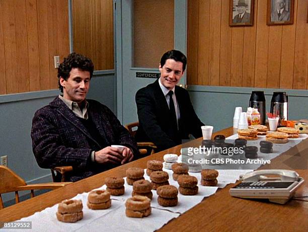 Michael Ontkean as Sheriff Harry S. Truman and Kyle MacLachlan as Special Agent Dale Cooper eye donuts arrayed on a table in a scene screen grab from...