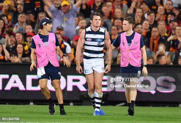 Patrick Dangerfield of the Cats is helped from the ground after colliding with Rory Sloane of the Crows during the First AFL Preliminary Final match...