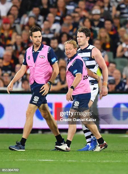 Patrick Dangerfield of the Cats is helped from the ground after colliding with Rory Sloane of the Crows during the First AFL Preliminary Final match...