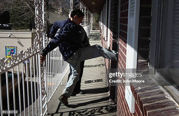 Hotel property manager Paul Martinez kicks in a tenant's door after no one answered the knock during an eviction February 26, 2009 in Colorado...