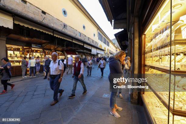 Pedestrians pass tourist jewelry stores on the Ponte Vecchio bridge in Florence, Italy, on Friday, Sept. 22, 2017. U.K. Prime Minister Theresa May...