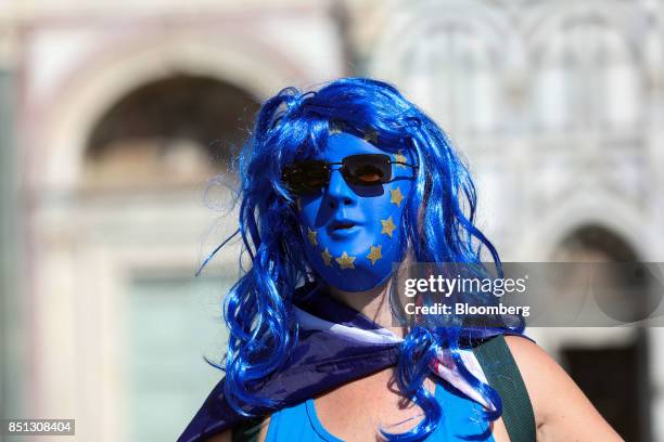 An anti-Brexit campaigner wearing a face mask featuring the colors and stars of the European Union flag outside the Basilica di Santa Maria Novella...