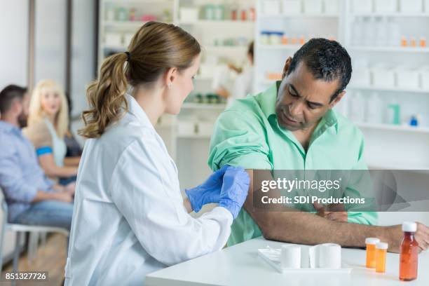 senior african american man receives flu shot - pharmacy vaccination stock pictures, royalty-free photos & images