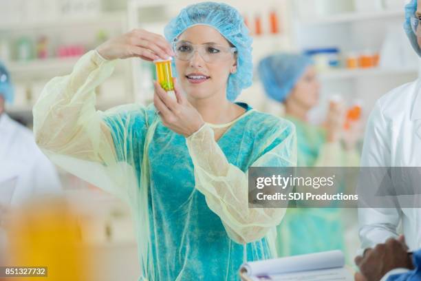 focused female pharmacist seals a medication container - pharmaceutical compounding stock pictures, royalty-free photos & images