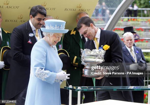 Queen Elizabeth II presents the leading trainer trophy to Aidan O'Brien during day five of the Royal Ascot meeting at Ascot Racecourse, Berkshire.