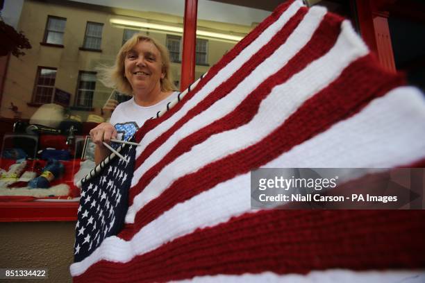 Mary Finn from Bridge Stores in New Ross in Co Wexford holds a woolen flag knitted by her daughter, as part of a celebration to mark the 50th...