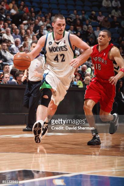Kevin Love of the Minnesota Timberwolves moves the ball up court against Anthony Parker of the Toronto Raptors during the game at Target Center on...
