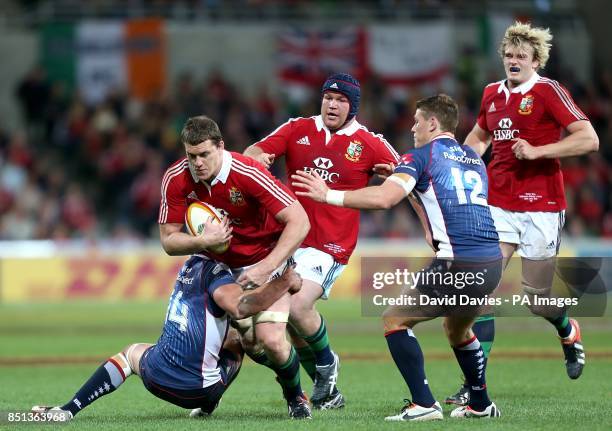 The British & Irish Lions' Ian Evans charges up the field past Melbourne Rebels' Tom English and Rory Sidey