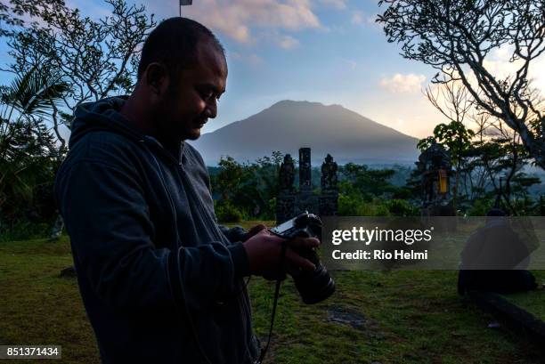 Photojournalist Made Nagi checks his images on the morning of the 20th after spending a sleepless night on volcano watch at the Mt Agung volcanolgy...