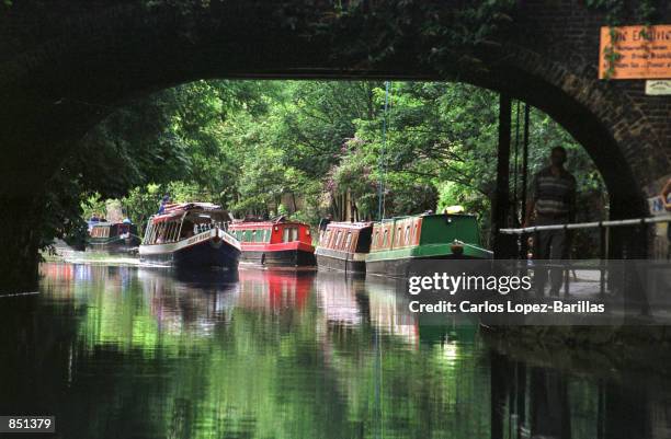 Narrow boat glides on Regents canal on it's way to Camden Lock July 30, 2000 in London, England. The Regent's Canal was built in 1820 to link the...