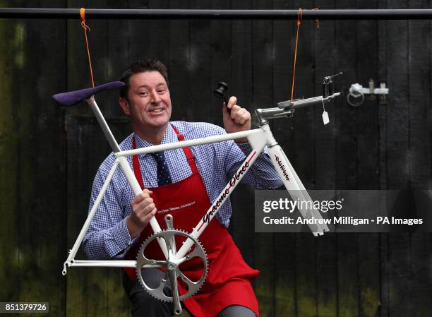 Auctioneer David Convery with a hand built bike frame by Graeme Obree, used by Greame at various time trials and was sold today at Great Western...