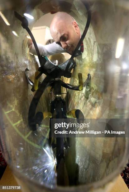 Auctioneer Gordon Watson views inside Graeme Obree's &quot;Beastie&quot; bike, valued at up to &pound;15,000 which went unsold today at Great Western...