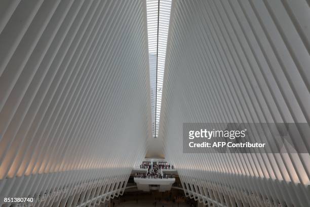 People walk at Westfield World Trade Center Mall on September 21 in New York. / AFP PHOTO / LUDOVIC MARIN