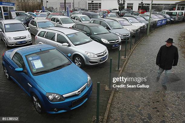 Man walks past new and used cars by German automaker Opel at a dealership on February 27, 2009 in Berlin, Germany. Opel, a subsidiary of troubled...