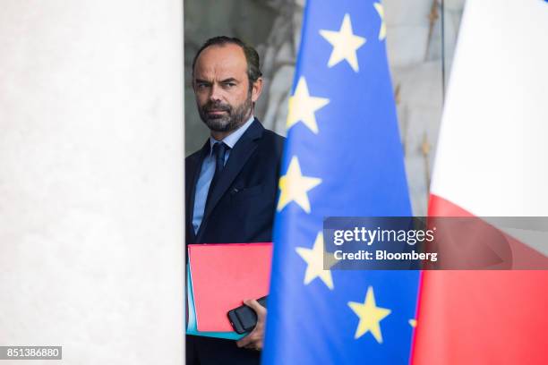 Edouard Philippe, France's prime minister, passes a European Union flag as departs following a cabinet meeting to approve labor law reforms at the...