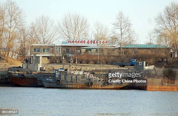 North Korean soldiers repair a boat outside a military barracks on the banks of the Yalu River near the North Korean town of Sinuiju, opposite...