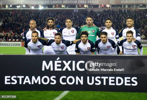 Players of San Lorenzo pose for a photo with a sign that reads "Mexico we are with you" prior to the first during the second leg match between Lanus...