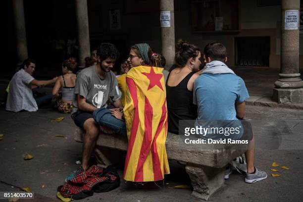 Girl draped in a Catalan pro-independence flag, 'Estelada', sits on a bench inside the rectory of the University of Barcelona during a protest on...