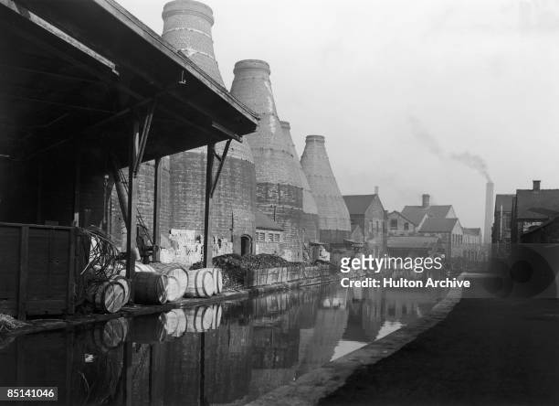 Canal running alongside bottle kilns belonging to potteries in Stoke-on-Trent, Staffordshire, circa 1948.