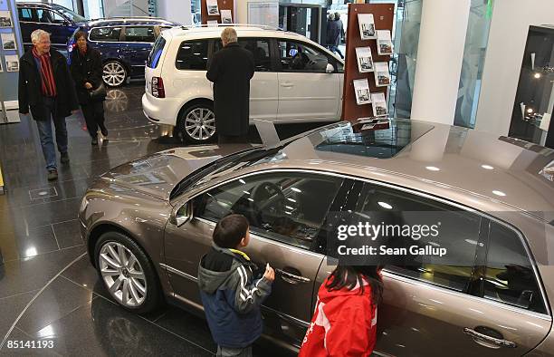 People look at new Volkswagen cars at the Auto Forum VW display rooms on February 27, 2009 in Berlin, Germany. Volkswagen announced that, despite the...