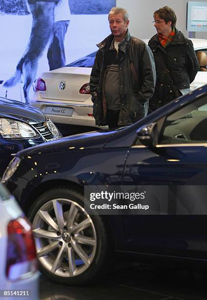 People look at new Volkswagen cars at the Auto Forum VW display rooms on February 27, 2009 in Berlin, Germany. Volkswagen announced that, despite the...