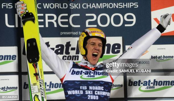 Switzerland's Andreas Kuettel celebrates on podium after winning the world ski jumping title of the men's Large Hill Individual Ski Jump event of the...