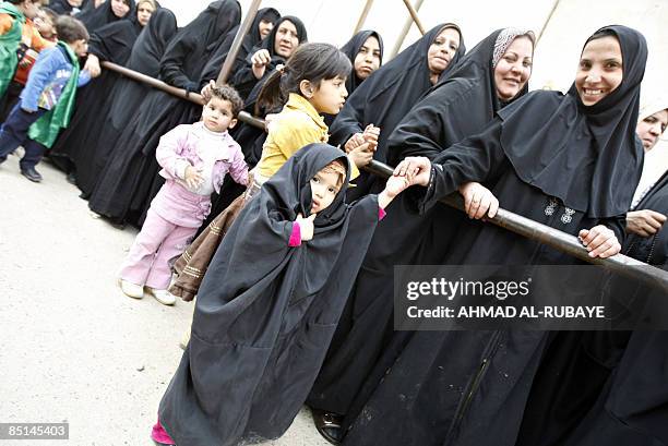 Shiite Muslim pilgrim women queue for a security search as they wait to visit the al-Askareyya Shrine which embraces the tombs of the 10th and 11th...