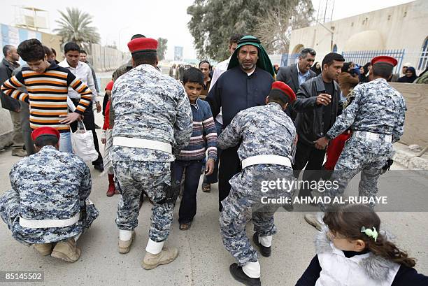 Shiite Muslim pilgrim men are frisked by security officers as they visit the al-Askareyya Shrine which embraces the tombs of the 10th and 11th Imams,...