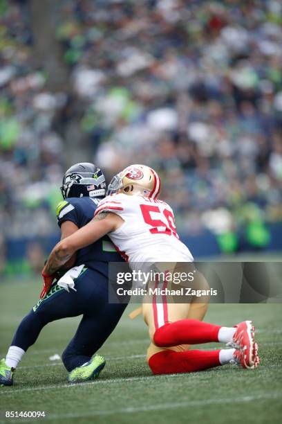 Aaron Lynch of the San Francisco 49ers tackles Russell Wilson of the Seattle Seahawks during the game at CenturyLink Field on September 17, 2017 in...